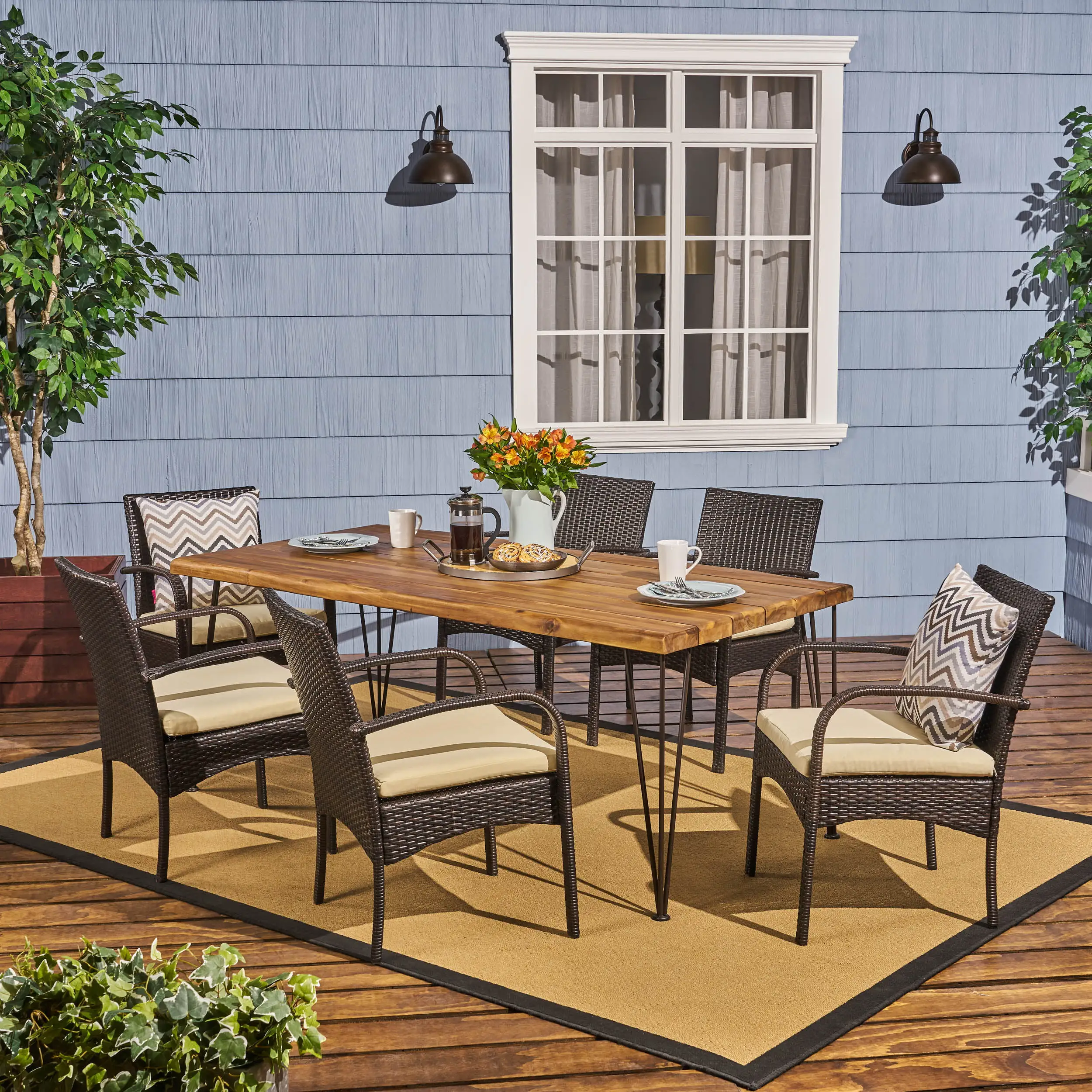 Leon Outdoor 72 Inch 7 Piece Acacia Wood Dining Set with Iron Table Legs and Wicker Chairs with Cushions. Teak. Rustic Metal. Multi-Brown. Cream